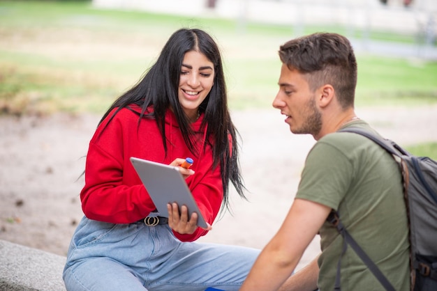 Students using a tablet in a park