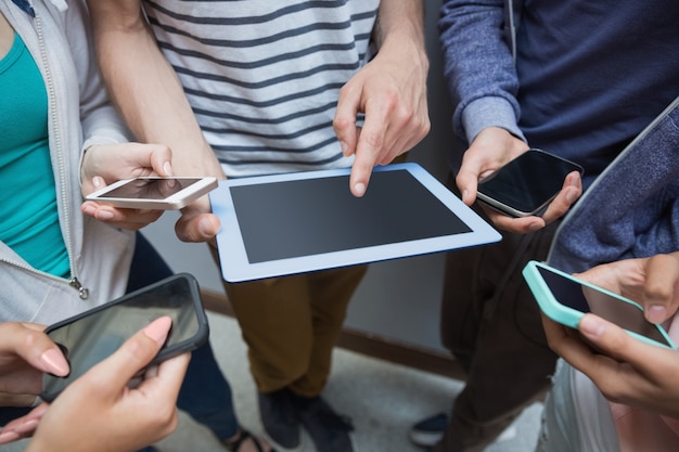 Students using tablet pc and their smartphones