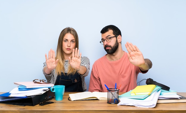 Students with many books making stop gesture and disappointed