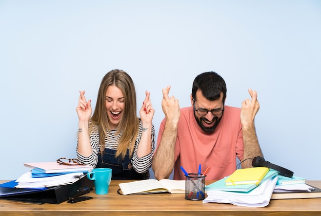 Foto studenti con molti libri con incrocio le dita