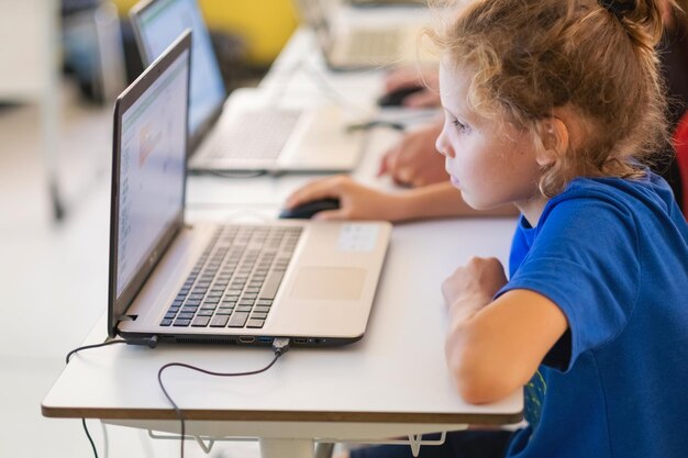 Foto studenti che lavorano ai computer portatili in classe di scuola elementare