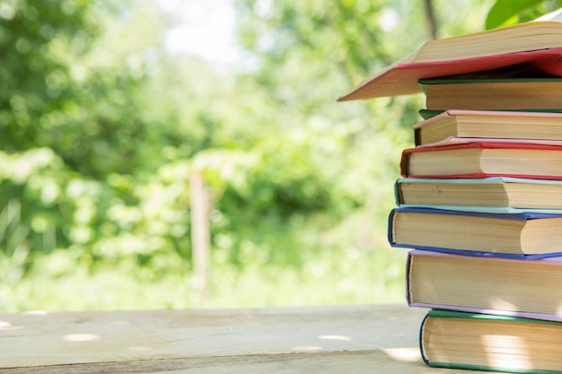 Studeren in zomer concept Open boek op een houten tafel in een tuin zonnige zomerdag