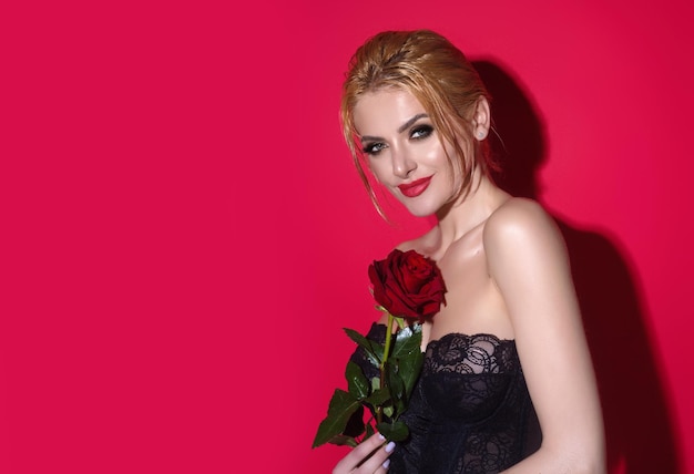 Studio beauty portrait of young beautiful sexy woman with red rose flower