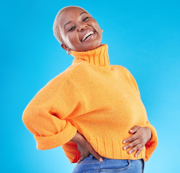 Studio blue background and happy African woman with fashion natural beauty and confidence in casual style or clothes Portrait smile and person with happiness in winter clothing or college student