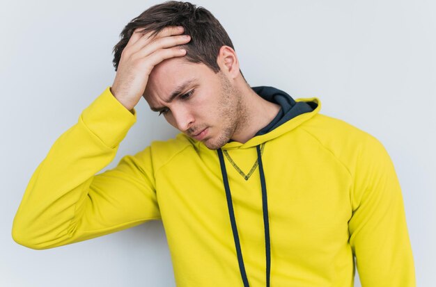 Studio horizontal portrait of male has headache massaging nose bridge to release tension after long working isolated on white studio background with copy spaceStress people health emotion concept