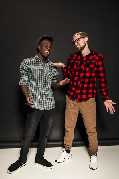 Photo studio lifestyle portrait of two best friends hipster boys going crazy and having great time togethe...