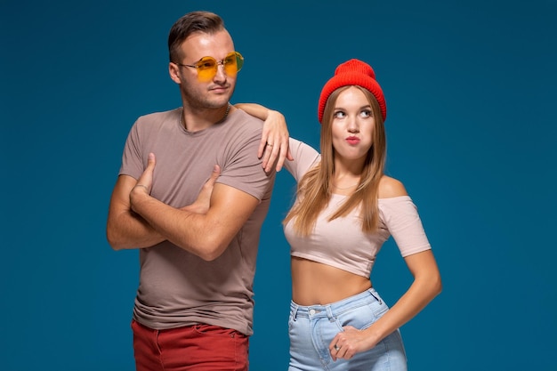 Studio lifestyle portret van twee beste vrienden hipster met stijlvolle heldere outfits, hoeden, denim shorts en brillen, gek worden en geweldige tijd samen hebben.