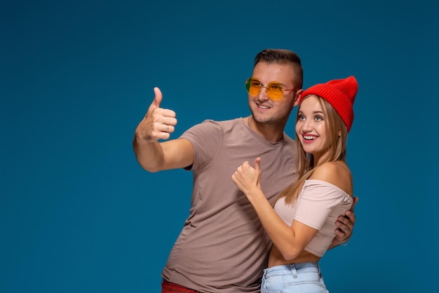 Studio lifestyle portret van twee beste vrienden hipster met stijlvolle heldere outfits, hoeden, denim shorts en brillen, gek worden en geweldige tijd samen hebben.