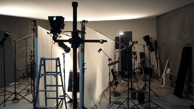 Foto configurazione dell'illuminazione da studio per la produzione di riprese fotografiche con molte apparecchiature come la carta per sfondi softbox, la schiuma riflettente bianca e molte altre