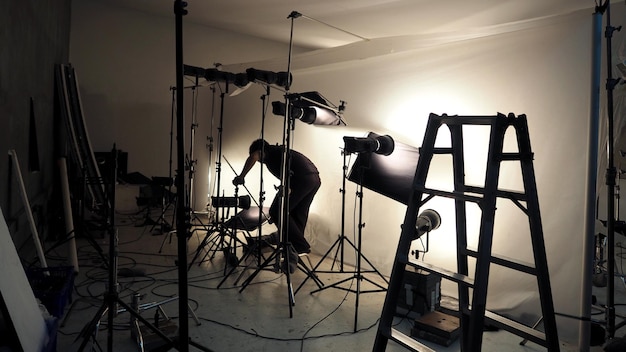 Foto configurazione dell'illuminazione da studio per la produzione di riprese fotografiche con molte apparecchiature come la carta per sfondi softbox, la schiuma riflettente bianca e molte altre