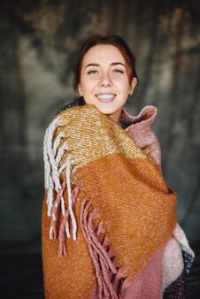 Studio live portrait of woman without makeup with beautiful smile is wrapped in an orange scarf