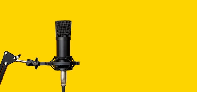 Студийный микрофон на желтом фоне.