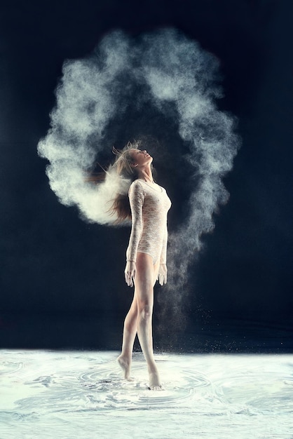 Studio muze Studio shot van een jonge vrouw die een spoor van poeder in de lucht achterlaat door met haar haren te zwaaien