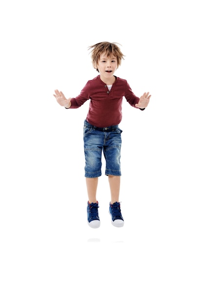 Studio opgewonden en jongen in portret voor sprong viering of vrolijk voor de eerste dag van de kleuterschool Mockup ruimte gelukkig kind en kind ontwikkeling met spel voor speelse energieke of witte achtergrond