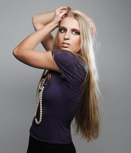 Foto studio-opname van een jonge, mooie, blonde, modieuze vrouw