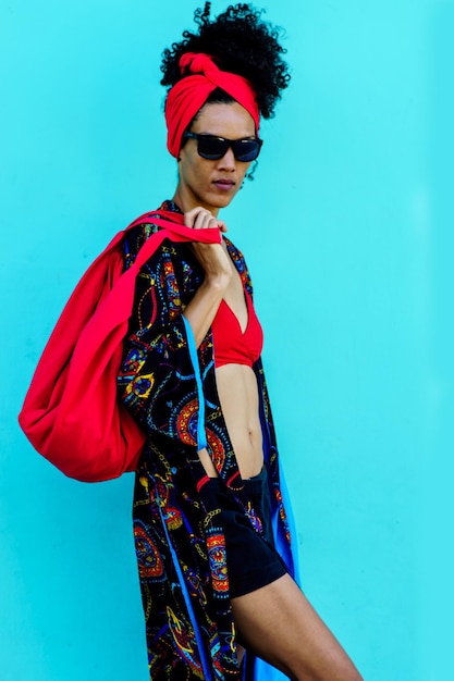 Studio photo of  a Brunette beauty woman posing with coloful summer clothes in a blue background