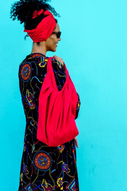 Studio photo of  a Brunette beauty woman posing with coloful summer clothes in a blue background