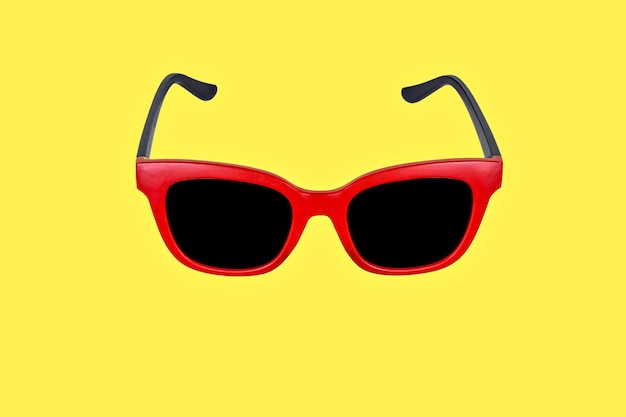 Photo studio photo with copy space of a red sunglasses in a yellow background