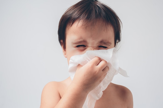 Studio picture from a baby with handkerchief. Sick child isolated has runny nose.