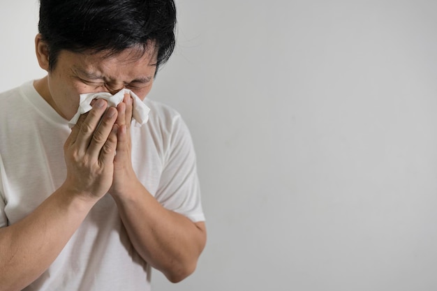 Studio picture from a young man with handkerchief Sick guy isolated has runny nose