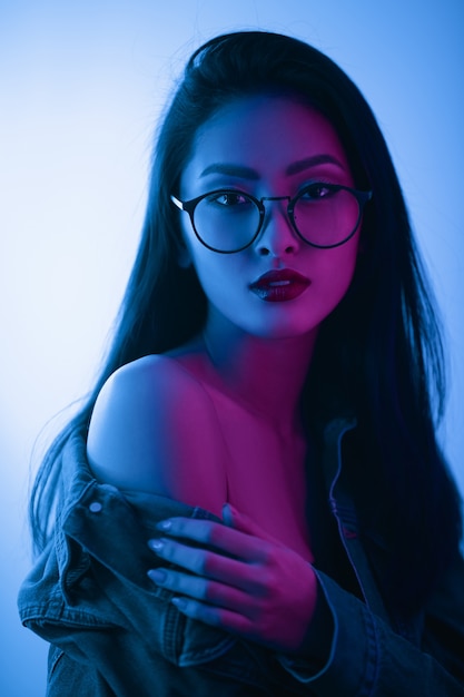 Studio Portrait of Asian Woman Over Urban Neon Lights.