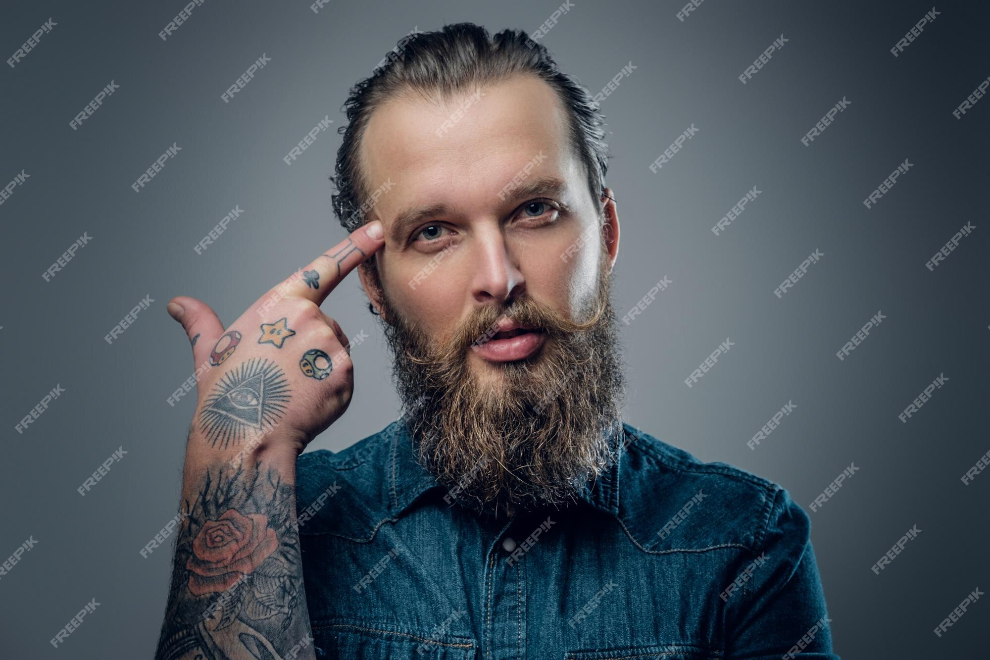 Premium Photo | Studio portrait of bearded male with tattoos on his arms, dressed in a denim shirt isolated on grey vignette background. Premium Photo | Studio portrait of bearded male with tattoos on his arms, dressed in a denim shirt isolated on grey vignette background.