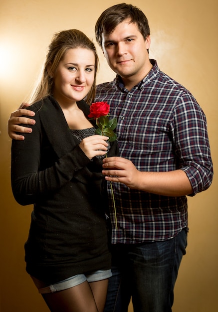 Studio portrait of beautiful couple in love hugging and looking at front