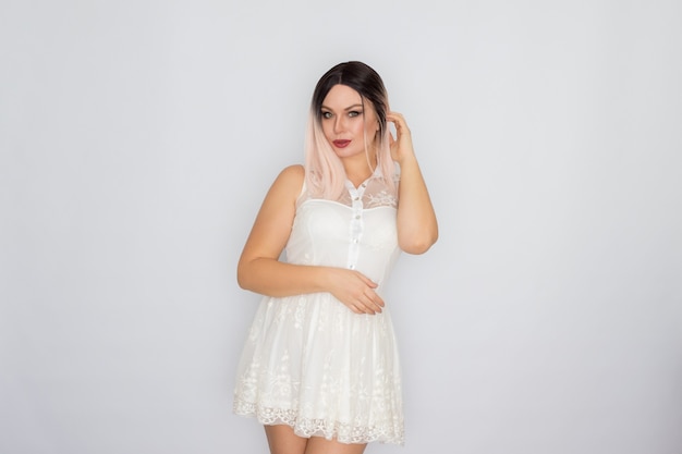 ロマンチックな白い夏のレースのドレスを着た美しい若いブロンドの女性のスタジオポートレート
