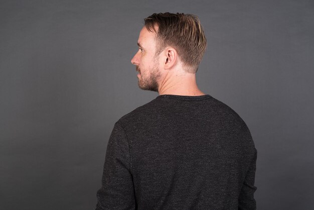 Studio portrait of blonde Caucasian man against gray background