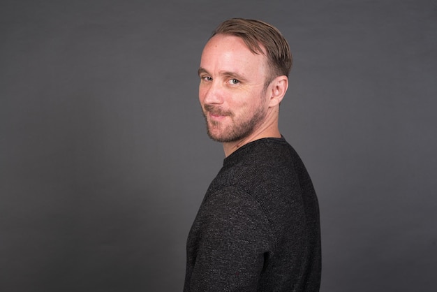 Studio portrait of blonde Caucasian man against gray background