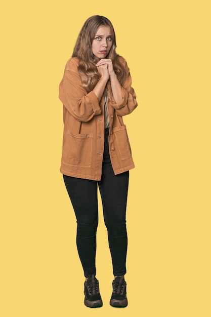 Studio portrait of a blonde Caucasian woman scared and afraid