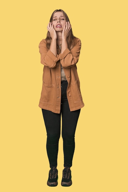 Photo studio portrait of a blonde caucasian woman whining and crying disconsolately