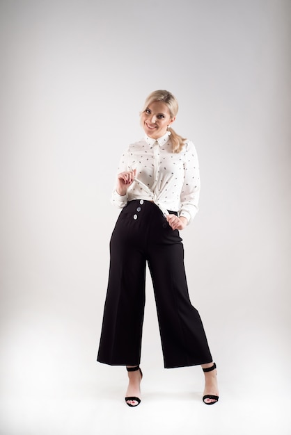 Studio portrait of blonde smiling positive business woman.