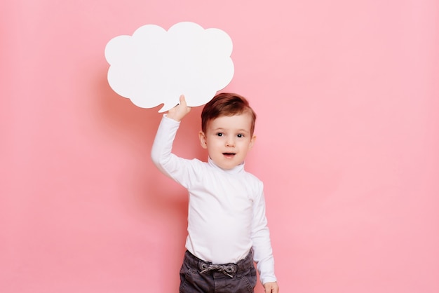 Studio portrait of a boy with a blank white board in the shape of a cloud