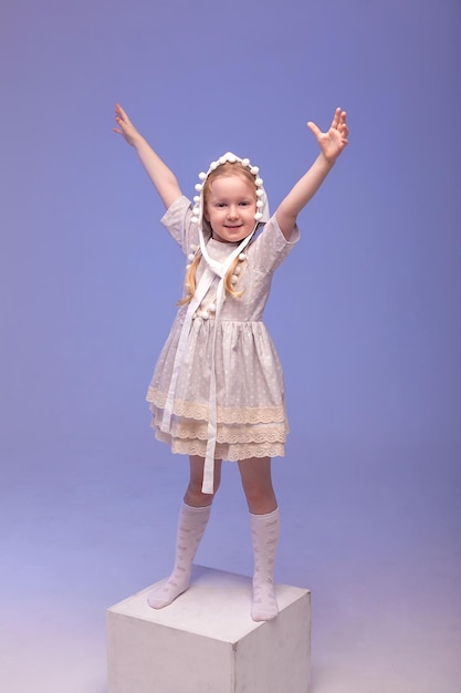 Studio portrait of a cute little girl in a funny hat dress and knee socks The dwarf costume An image with selective focusing and tinting