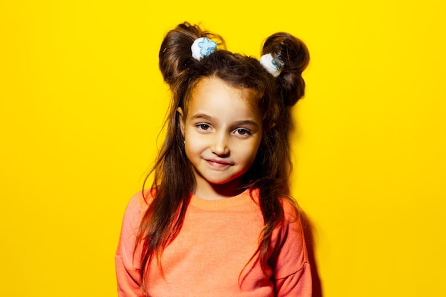 Studio portrait of cute teenager girl on yellow