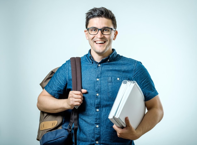 Studio portrait of handsome young man with backpack