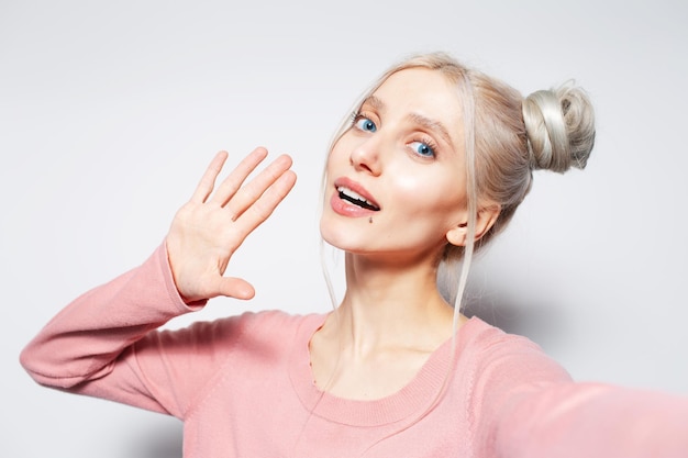 Studio portrait of happy beautiful blonde girl on white background