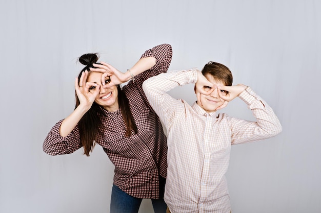 Studio portrait of happy family mom and teenager son boy in colored glasses having fun