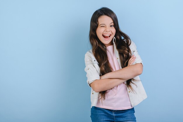 Studio portrait of happy girl winks. 