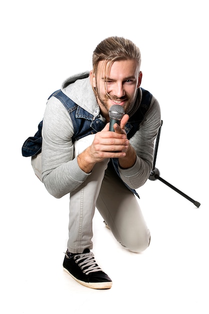 Studio portrait of a man singing with microphone isolated on white