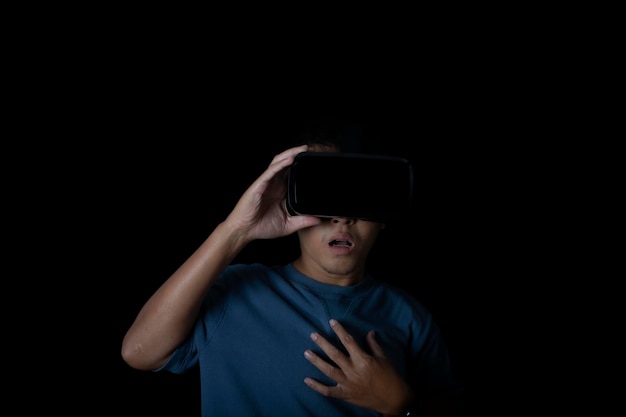 VR 헤드셋을 착용한 스튜디오 초상화 남자는 가상 현실 기술 게임 엔터테인먼트 및 사람 개념의 검은 배경 안경에 충격을 받거나 놀랐습니다.