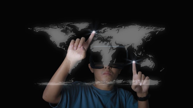 Photo studio portrait man wearing vr headset touching world map against on black background glasses of virtual reality and exploring the metaverse technology gaming entertainment concept