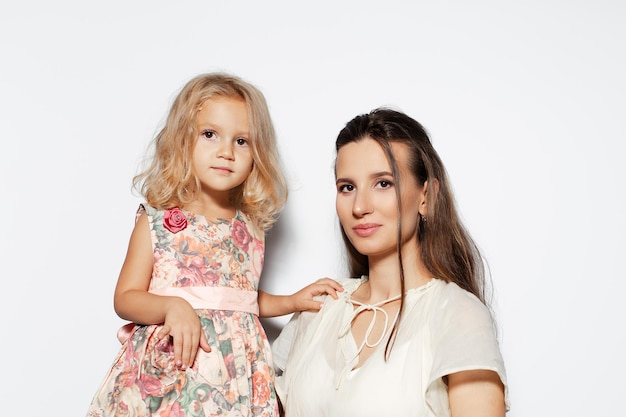 Фото Студийный портрет молодой матери с дочерью на белом фоне