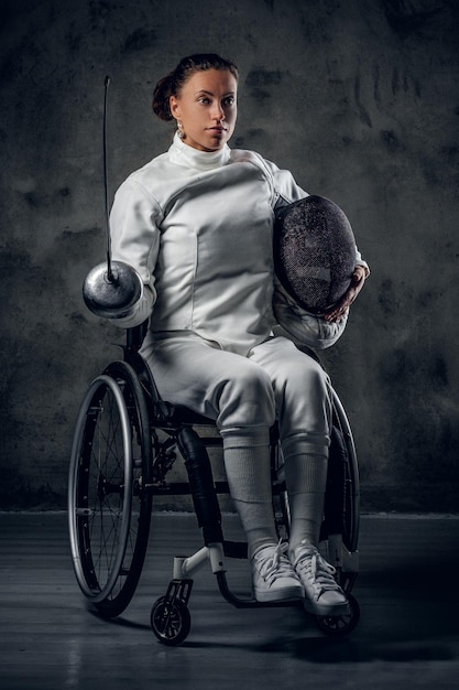 Studio portrait of paralympic female fencer in wheelchair.