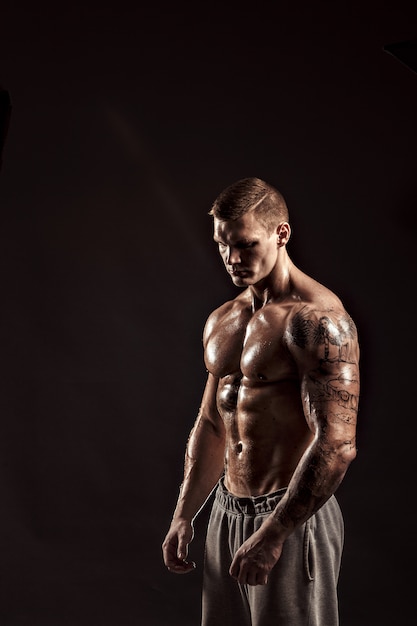 Studio portrait of a shirtless athletic tattooed male