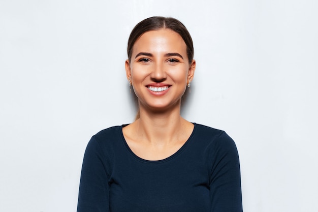 Ritratto dello studio di giovane ragazza sorridente del brunette.