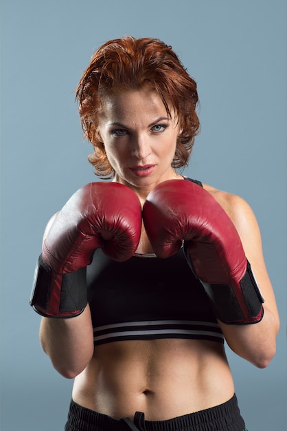 Studio portrait of sporty mature woman in boxing gloves