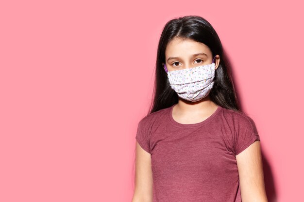 Studio portrait of teenage girl wearing medical face mask against coronavirus