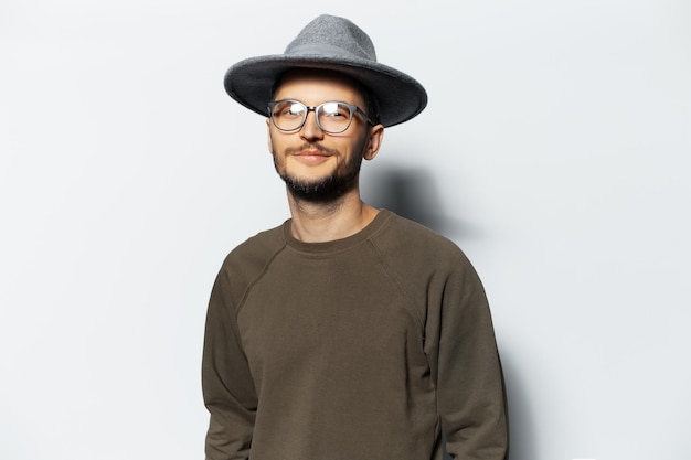 Photo studio portrait of young handsome guy wearing grey hat eyeglasses